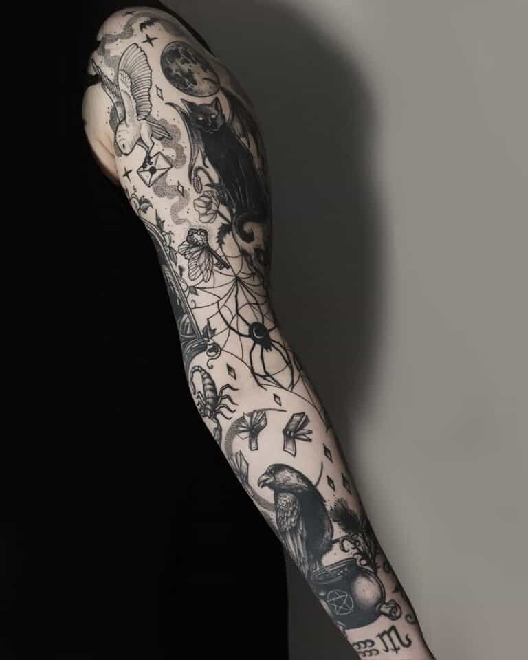 Ramię osoby zdobi misterny czarno-biały tatuaż na rękawie wykonany pieczołowicie w studiu Seven Sins Tattoo w Poznaniu. Szczegółowe wzory zawierają elementy takie jak łapacz snów, czarny kot, wrona, sowa, księżyc i różne mistyczne i geometryczne symbole na jednolitym tle. Osoba ma na sobie czarny top bez rękawów.