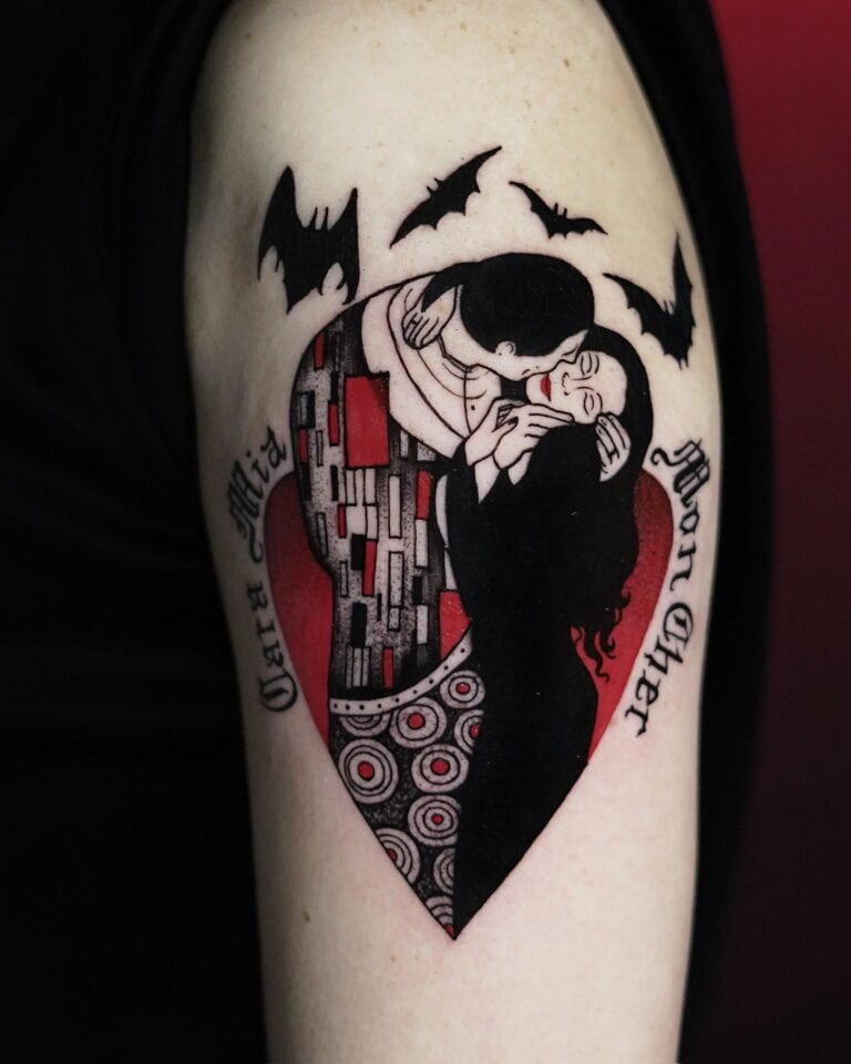 Tatuaż z Seven Sins Tattoo, najlepszego studia tatuażu w Poznaniu, przedstawia stylizowaną parę w objęciach w kształcie serca. Serce jest ozdobione skomplikowanymi wzorami i umieszczone na czerwonym tle. Po lewej stronie widnieją frazy „Cara Mia”, a po prawej „Mon Cher”, a nad tym arcydziełem latają nietoperze. Ten wzór został uchwycony na zdjęciu produktu DSC00604 na 7sinstattoo.pl.