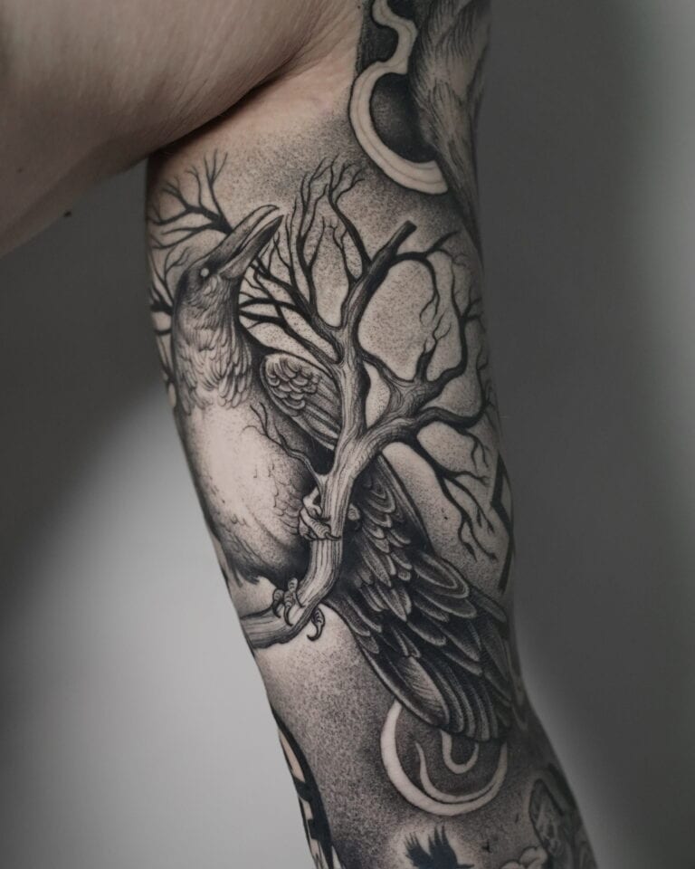 7sinstattoo.pl Szczegółowy czarno-szary tatuaż, oznaczony jako DSC03442 i stworzony w Najlepszym Studio Tatuażu Poznań, przedstawia kruka siedzącego na sękatej gałęzi drzewa na ramieniu człowieka. Wzór charakteryzuje się misternym cieniowaniem i cienkimi liniami, dzięki czemu zarówno ptak, jak i gałąź wyglądają realistycznie. Najlepsze studio tatuażu Seven Sins Tattoo