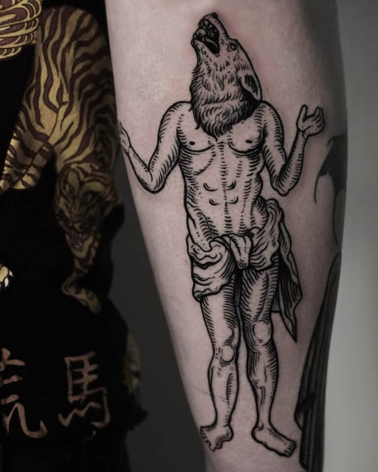 7sinstattoo.pl Tatuaż uchwycony w DSC04263 na ramieniu przedstawia ludzkie ciało z głową wilka. Postać stoi z uniesionymi i lekko zgiętymi w łokciach ramionami. Wytatuowany w tatuaż Poznań, na ramieniu znajdują się również inne tatuaże, a osoba ma na sobie czarną koszulę ozdobioną żółto-białym wzorem.
 Najlepsze studio tatuażu Seven Sins Tattoo