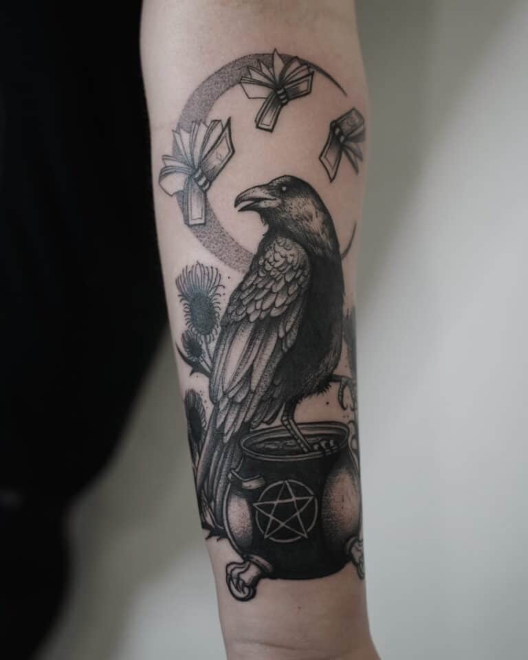 7sinstattoo.pl Szczegółowy czarno-szary tatuaż (DSC08830ррр) na ramieniu przedstawia wronę siedzącą na kotle ozdobionym symbolem pentagramu. Nad wroną znajduje się zakrzywiony układ unoszących się książek, wszystko na tle roślin przypominających osty, które podkreślają mistyczny motyw. Ten misterny element został umiejętnie wykonany w Studio Tatuażu Poznań. Najlepsze studio tatuażu Seven Sins Tattoo