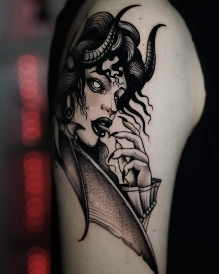 7sinstattoo.pl Czarno-szary tatuaż o nazwie DSC09961 przedstawia kobietę o rogowych rysach twarzy, kręconych włosach i intensywnym wyrazie twarzy. Trzyma rękę blisko twarzy, pokazując widoczne kły i spiczaste paznokcie. Tło jest rozmyte czerwonymi i czarnymi tonami. Stworzony w studio tatuażu Poznań, ten uderzający element zdobi górną część ramienia. Najlepsze studio tatuażu Seven Sins Tattoo