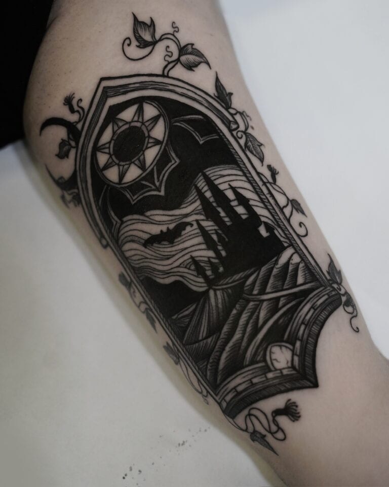7sinstattoo.pl Oszałamiający czarny tatuaż na skórze, oznaczony jako DSC09965, przedstawia gotyckie okno łukowe oplecione misternymi pnączami. W oknie ciemny zamek znajduje się na tle księżycowego nieba pełnego nietoperzy i chmur. Nad łukiem symbol słońca zapewnia uderzający kontrast z nocną sceną poniżej — prawdziwe arcydzieło tatuażysty Poznań w studio tatuażu Poznań. Najlepsze studio tatuażu Seven Sins Tattoo