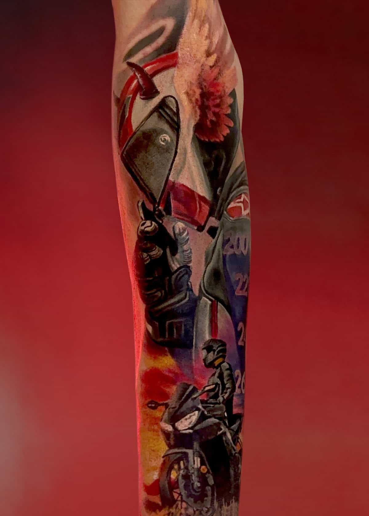 7sinstattoo.pl Szczegółowy tatuaż motocyklisty na przedramieniu, wykonany w studio tatuażu Poznań, przedstawia zbliżenie dłoni w rękawiczce trzymającej kask motocyklowy, a także obraz całego ciała motocyklisty i jego motocykla na tle żywej czerwieni. Ten wzór jest częścią kolekcji x52. Najlepsze studio tatuażu Seven Sins Tattoo